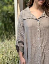 Vestido camisero amplio y largo de lino color azul, con botones de nácar, cuello camisero y bolsillos laterales.