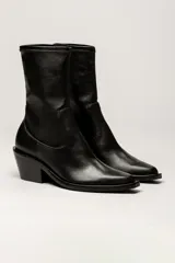 Bota de caña media color negro, de cuero sintético, con puntera cuadrada y taco geométrico.