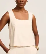 Blusa sin mangas color crema, confeccionada en viscosa, con escote cuadrado.