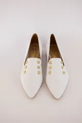 Chatitas negras de cuero con punta fina y apliques de tachas doradas.