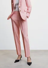 Pantalón de vestir color rosa, de corte recto y largo, con trabillas para cinturón, bolsillos laterales y cierre oculto con botón, gancho y cremallera.