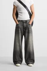 Pantalón de jean negro de corte amplio, con cinco bolsillos, efecto lavado y cierre frontal con cremallera y botón.