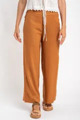 Pantalón de lino color ocre, de corte recto y tiro medio, con lazo de ajuste en la cintura.