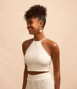 Blusa cropped blanca de encaje con cuello halter, breteles finos con lazo en la espalda y lastex en la espalda.