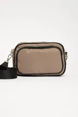 Bandolera rectangular color beige con tres compartimentos con cierre y correa larga negra regulable.
