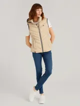 Chaleco acolchado Tommy Hilfiger color beige con capucha ajustable con cordones y cierre de cremallera frontal. Cuenta con bolsillos laterales con cremallera y detalles distintivos de la marca.