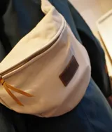 Riñonera de cuero color marrón, con correa regulable y bolsillo interno con cierre.