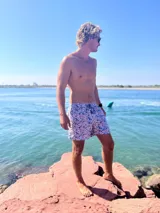 Short de baño blanco con estampado floral en tonos celeste y rosa.