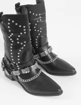 Botas texanas negras de cuero sintético con tachas plateadas y arnés decorativo con hebillas metálicas.