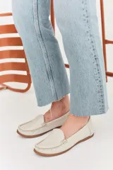 Mocasines de cuero color marrón claro con costuras a la vista.