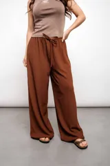 Pantalón ancho color marrón con elástico ajustable en la cintura.