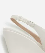 Zapato de tacón tipo anabela (cuña) color marrón oscuro, con punta fina y diseño slingback con tira elástica en el talón. Confeccionado en poliuretano con acabado liso.