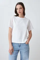 Remera blanca de algodón con mangas cortas con detalle de broderie calado.