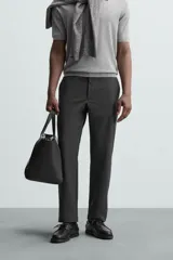 Pantalón chino de vestir negro, corte slim fit, con bolsillos laterales y traseros. Cierre frontal con cremallera y botón.