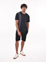 Remera negra de corte oversized con bolsillo en el pecho y detalle de bloque gris en el lateral.