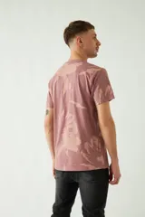 Remera color ladrillo con estampado abstracto en tonos beige y logo de la marca Mistral en el pecho.