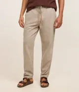 Pantalón relaxed de hombre confeccionado en tejido oxford de algodón color beige, con trabillas en la cintura y cordón para lazo.