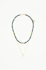 Collar doble con una cadena de piedras facetadas azules y verdes, y una cadena dorada de bolitas con un dije de corazón dorado.