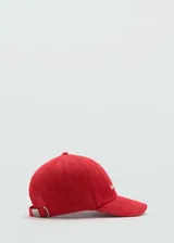 Gorra de algodón roja con visera y correa ajustable plateada en la parte posterior.