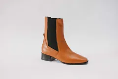 Botas de cuero rojas con elástico negro en los laterales, punta cuadrada y taco bajo.