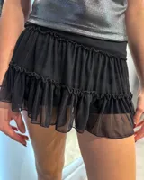 Minifalda negra con volados de tul y cintura elástica.