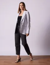 Blazer blanco con rayas verticales negras, cuello con solapa, abertura central con botón y bolsillos delanteros.