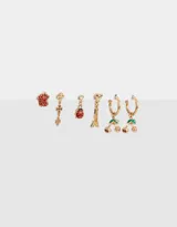 Set de aros dorados con strass, que incluye aros pasantes y argollas con multidijes de cerezas, mariquitas, tréboles, torre eiffel y otros motivos.
