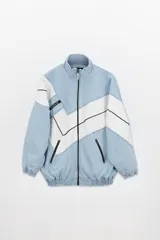 Campera estilo olímpica de jean celeste con recortes geométricos blancos.