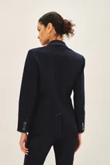 Blazer azul marino de denim con forro azul satinado, solapas de muesca, cierre frontal con un botón, bolsillos delanteros con solapa y puños con botones.