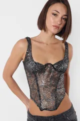 Corset lencero en tejido desagujado con foil, color gris y plateado. Recortes en delantero con ballena en interior. Busto con aro; taza media copa y superposición de breteles. Terminaciones con elástico dobladillado por interior. Acceso por espalda con cierre metálico YKK desmontable.