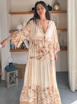 Vestido largo de estilo campesino con estampado de palmeras en tonos blanco y negro, con escote en V y mangas largas abullonadas.