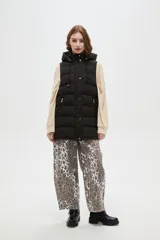 Chaleco puffer negro con capucha ajustable, cierre frontal con botones a presión y bolsillos laterales con cierre.