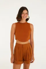 Top color beige, corte crop, con escote redondo y tirantes anchos.