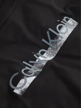 Remera negra de algodón regenerado con cuello redondo, mangas cortas y estampado gráfico con logo de Calvin Klein en el pecho.