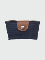 Sombrero tipo bucket reversible, negro de un lado y beige del otro, con detalle de cuero marrón con botón metálico en el lateral.