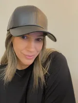 Gorra color beige de cuero sintético con visera y ajuste trasero con velcro.