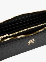Billetera Tommy Hilfiger negra con diseño de monogramas TH en relieve y cierre de cremallera.