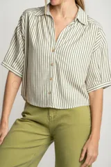 Camisa oversize a rayas verticales color verde y blanco, con cuello clásico, manga corta y cierre frontal con botones.