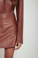 Campera corta de cuero ovino color caramelo, de mangas largas acampanadas y cuello camisero.