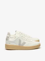 Zapatillas urbanas Veja V-90 color blanco hueso con logo lateral en gris y suela color caramelo.