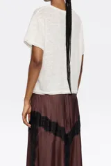 Remera color crudo de corte crop con cuello redondo y mangas cortas.