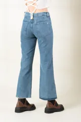 Pantalón de jean azul claro, corte bootcut, con bolsillos delanteros y traseros, y aberturas laterales en el ruedo.