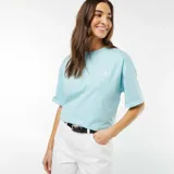 Camiseta celeste de manga corta con cuello redondo y estampado de Mickey Mouse surfeando.