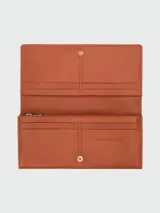 Billetera continental Longchamp Le Roseau color terracota con cierre de broche metálico dorado.