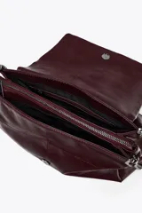 Bolso de hombro marrón oscuro de cuero sintético, con solapa y cierre magnético. Tiene un asa de cadena plateada y tres compartimentos internos, uno de ellos con cierre de cremallera.