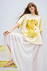 Remera color crema de corte amplio con estampado de girasoles en un jarrón y la firma 'Vincent'.