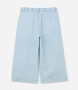 Pantalón tipo pantacourt de jeans en tono delavê, con corte amplio y largo a media pantorrilla. Presenta cintura con elástico en la espalda, cierre frontal con botón forrado, bolsillos laterales tipo cuchillo y pliegues delanteros.