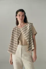 Chaleco marrón con solapas amplias y terminaciones envivadas. Diseño reversible y sin mangas.