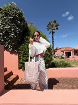 Bolso tipo shopper de color rojo con doble asa de mano y correa larga ajustable y extraíble. Presenta un diseño funcional con un bolsillo frontal abierto y gran capacidad interna.