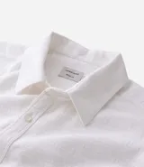 Camisa de manga corta blanca con textura de rayas, cuello inglés y abotonadura frontal.